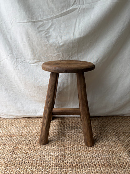 Vintage mid brown four legged wooden stool with round top