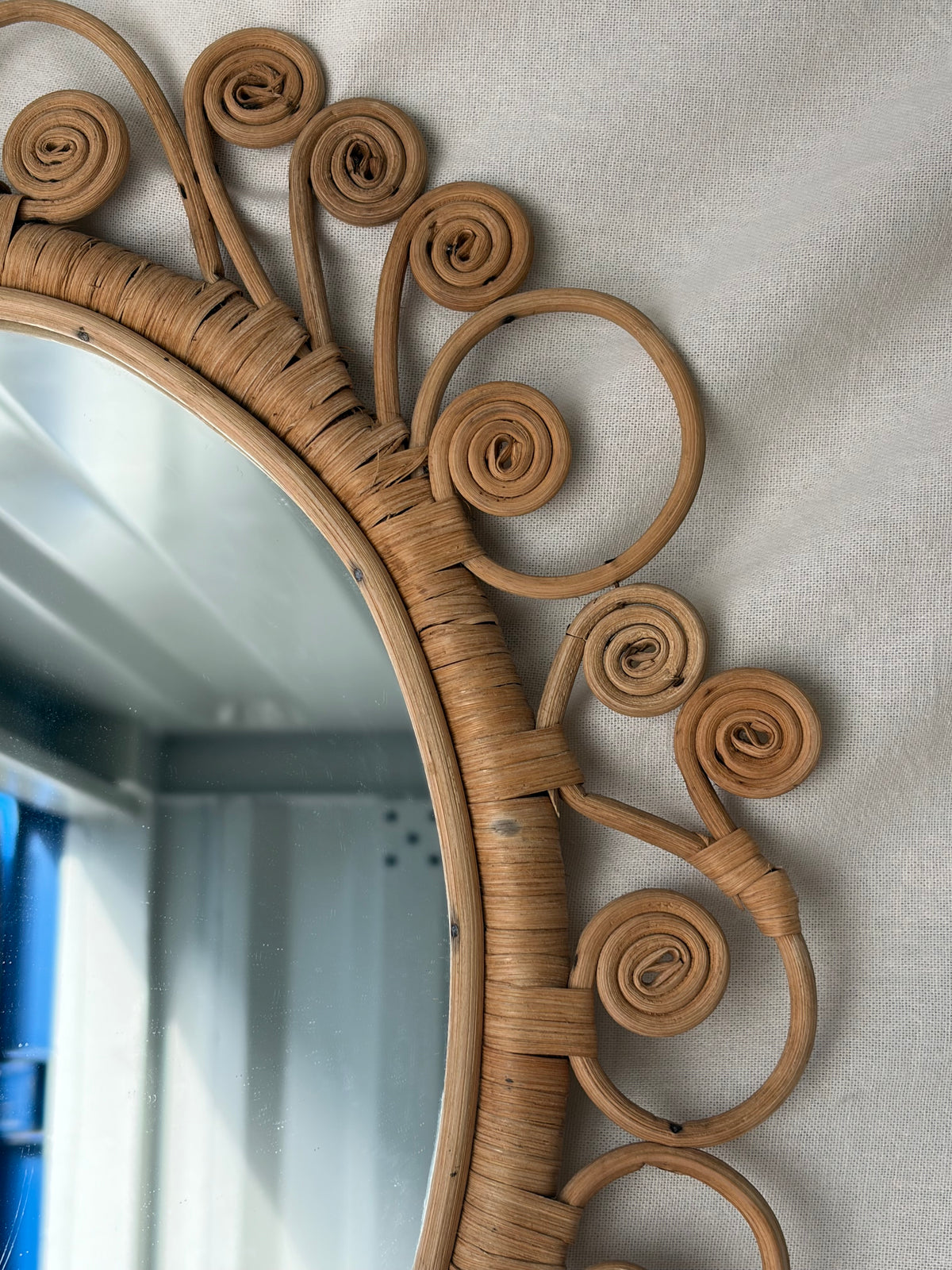 Vintage oval rattan mirror with scrollwork swirls