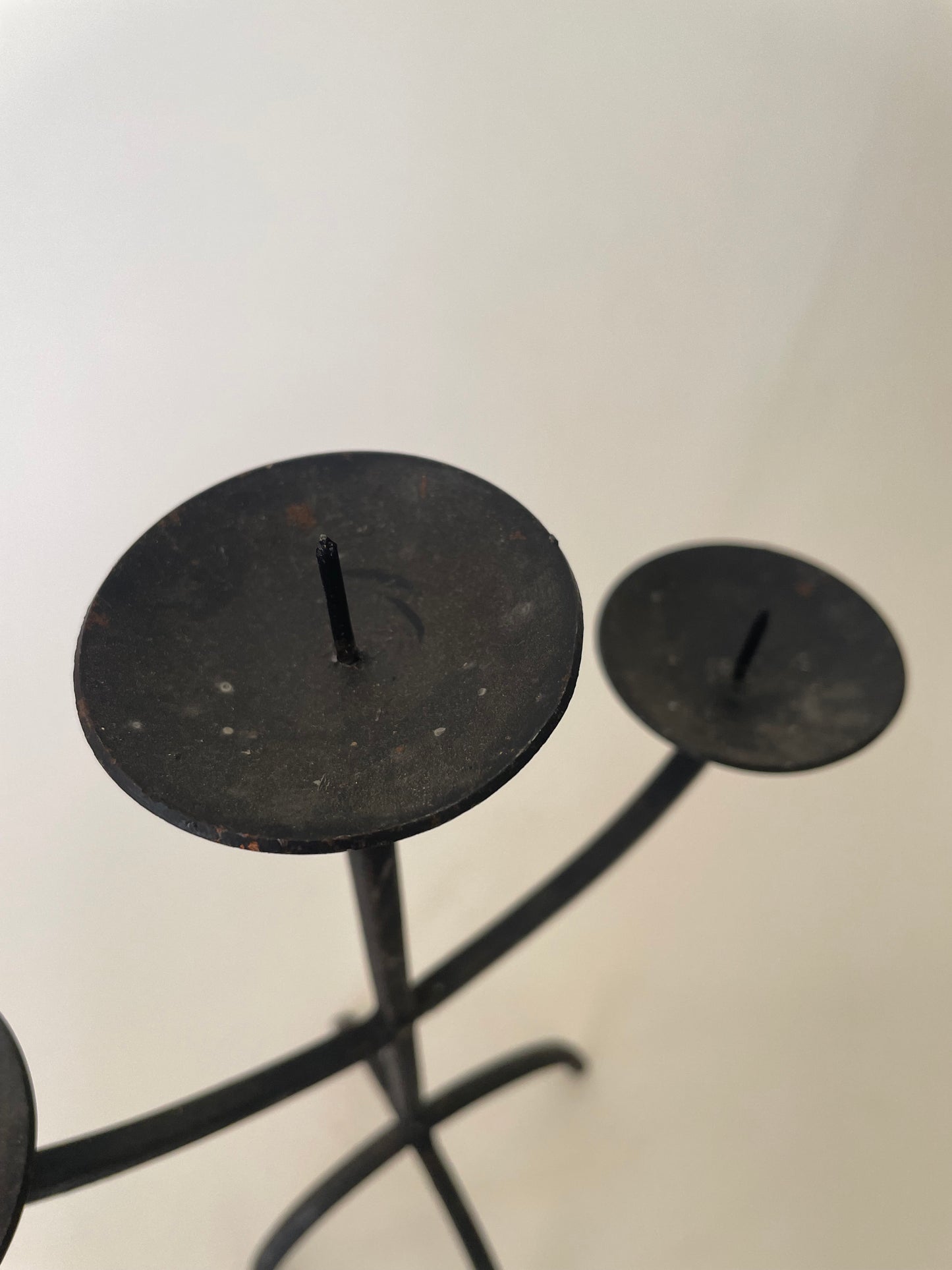 Black wrought iron three pronged candlestick holder