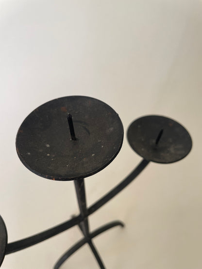 Black wrought iron three pronged candlestick holder