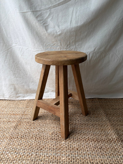 Vintage light wooden four legged stool with round top