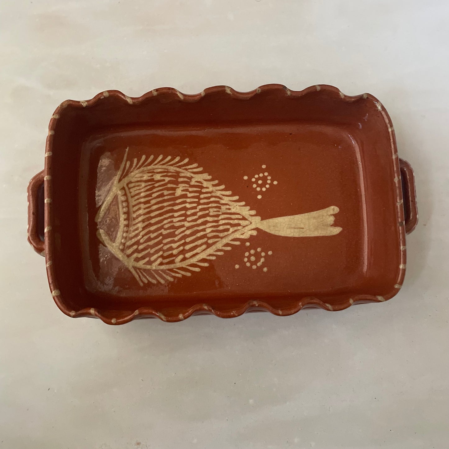 Terracotta dish with fish design