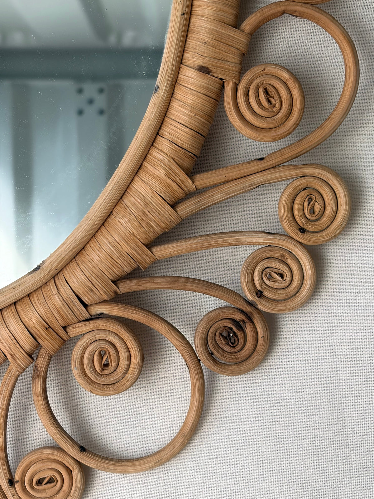 Vintage oval rattan mirror with scrollwork swirls