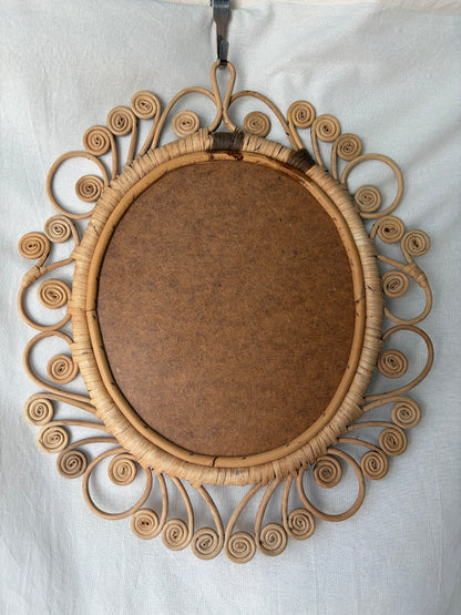 Vintage oval rattan mirror with scrollwork swirls