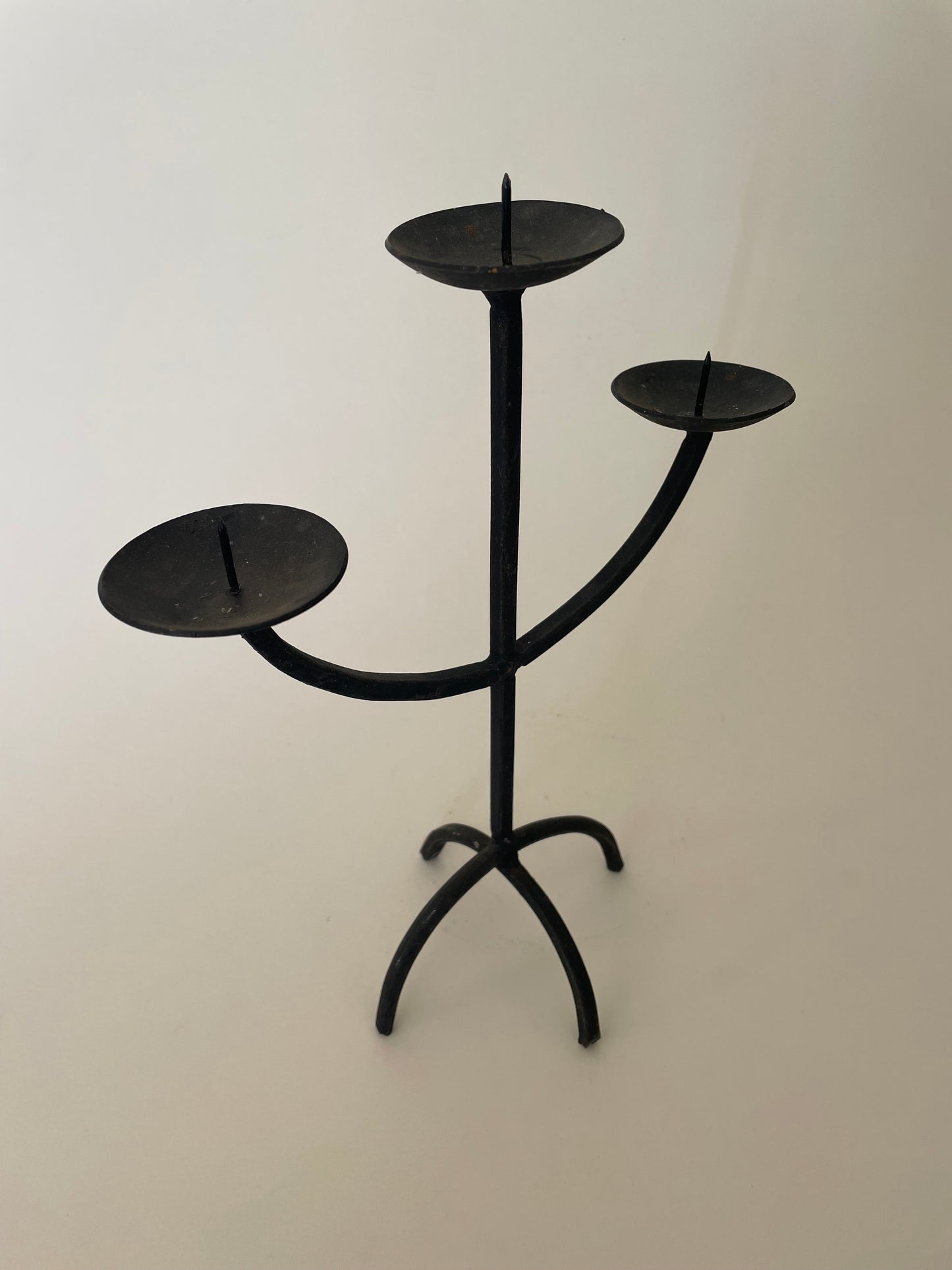 Black wrought iron three pronged candlestick holder