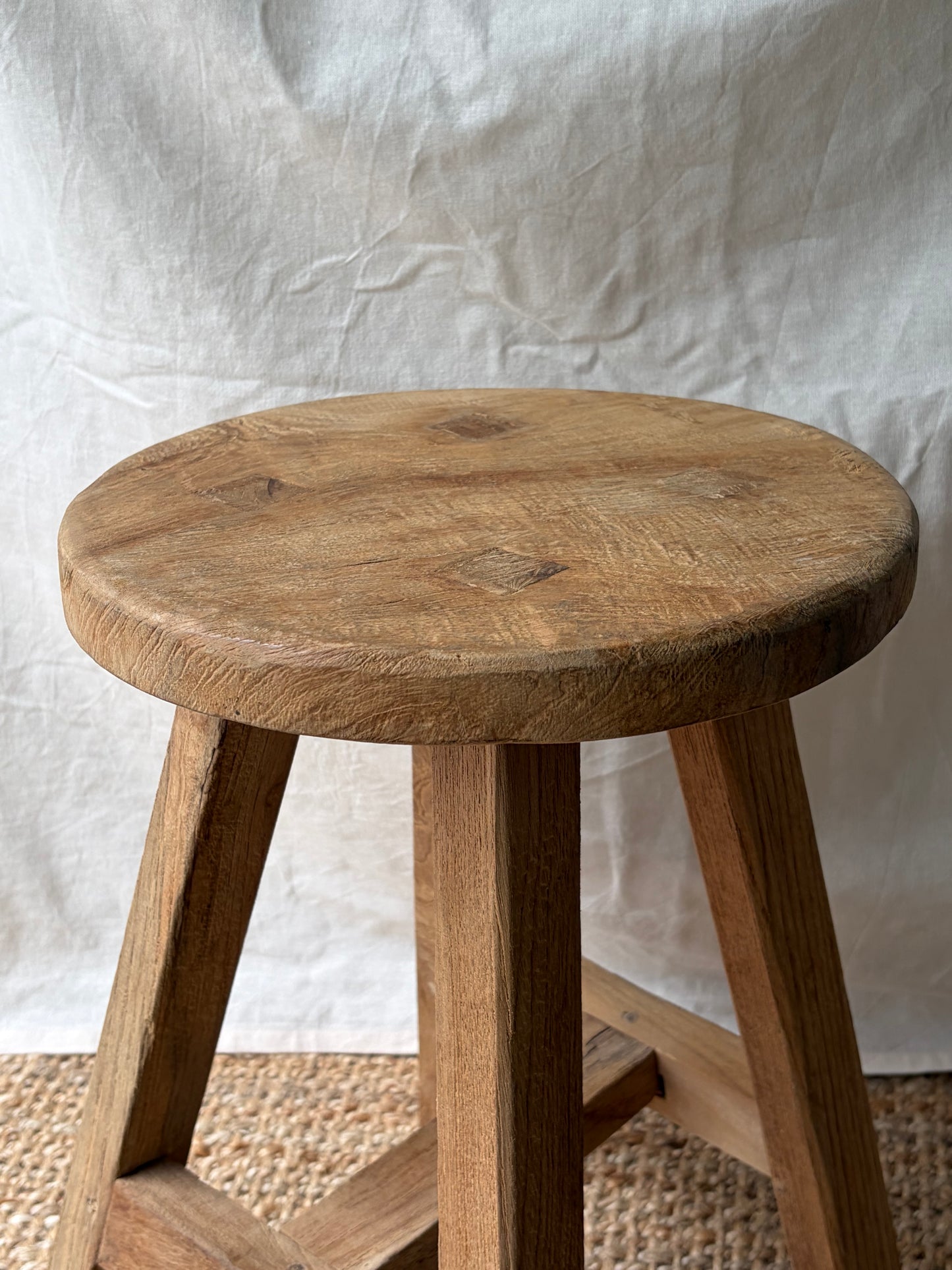 Vintage light wooden four legged stool with round top