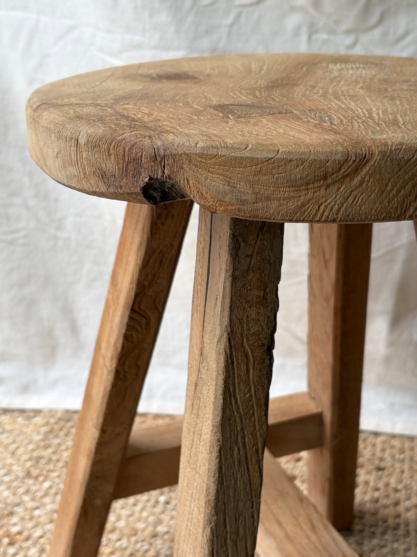 Vintage light wooden four legged stool with round top