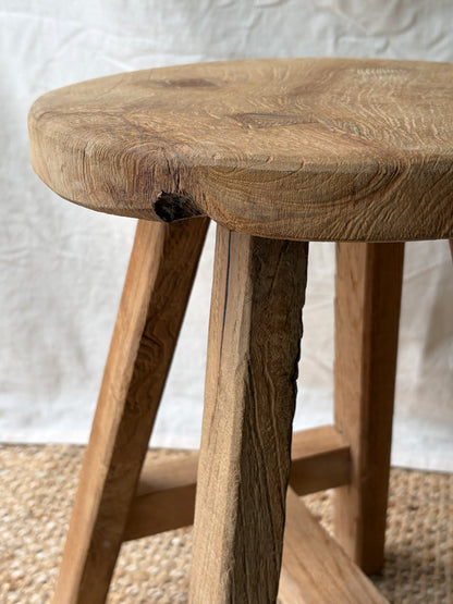Vintage light wooden four legged stool with round top