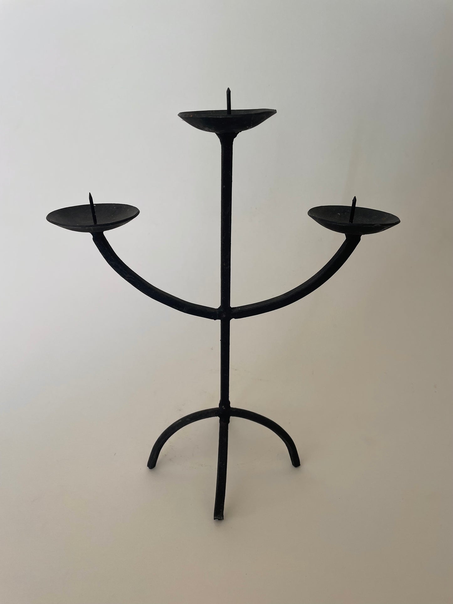 Black wrought iron three pronged candlestick holder