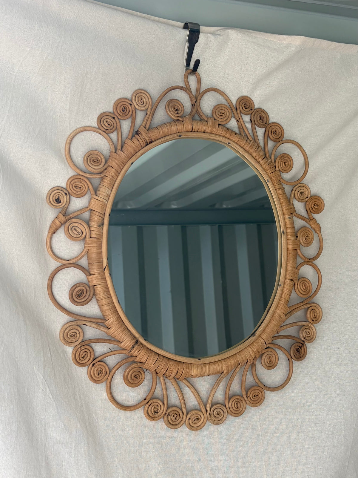 Vintage oval rattan mirror with scrollwork swirls