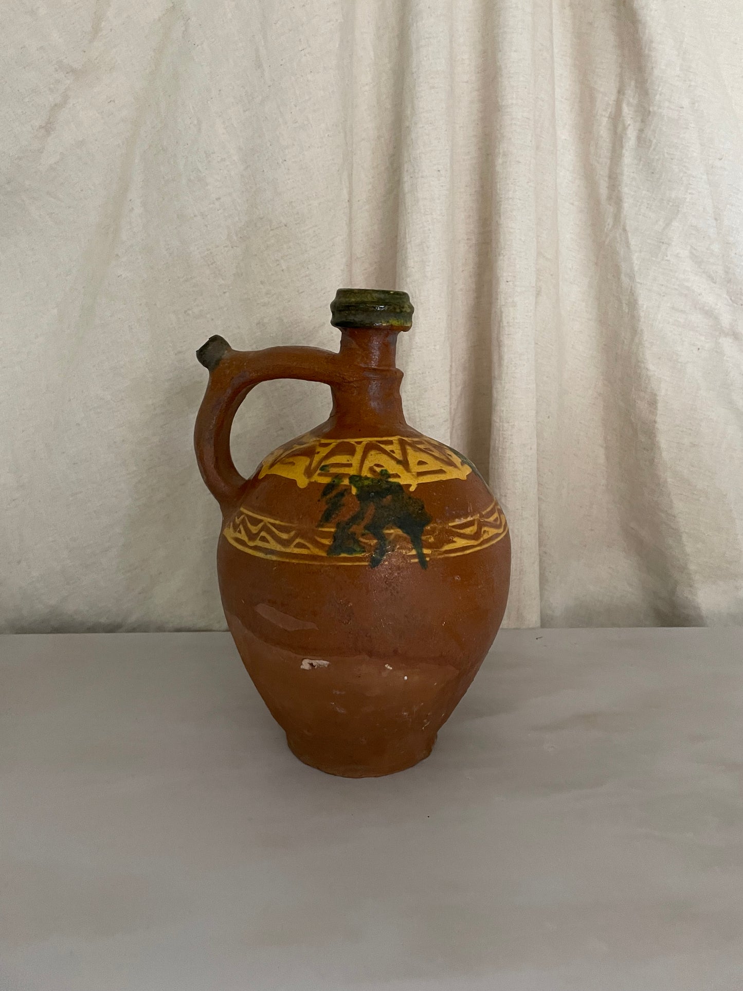 Terracotta jug with yellow and green